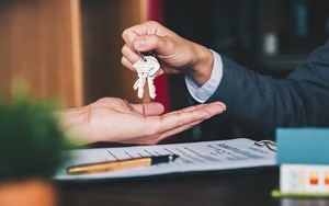 One person hands over keys to another