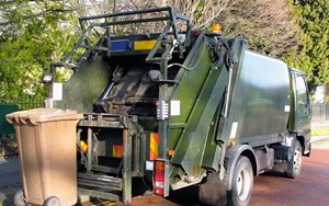 a refuse truck collects a brown bin