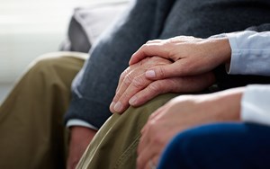 Two people hold hands
