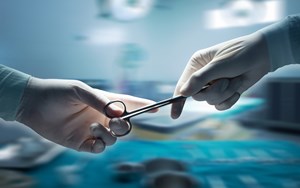 one surgeon hands scissors to another