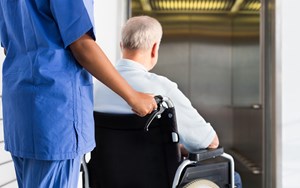 a nurse pushes a patient in a wheelchair