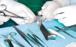 a surgeon cutting a mesh implant