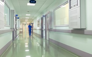 a nurse walks down a hospital corridor