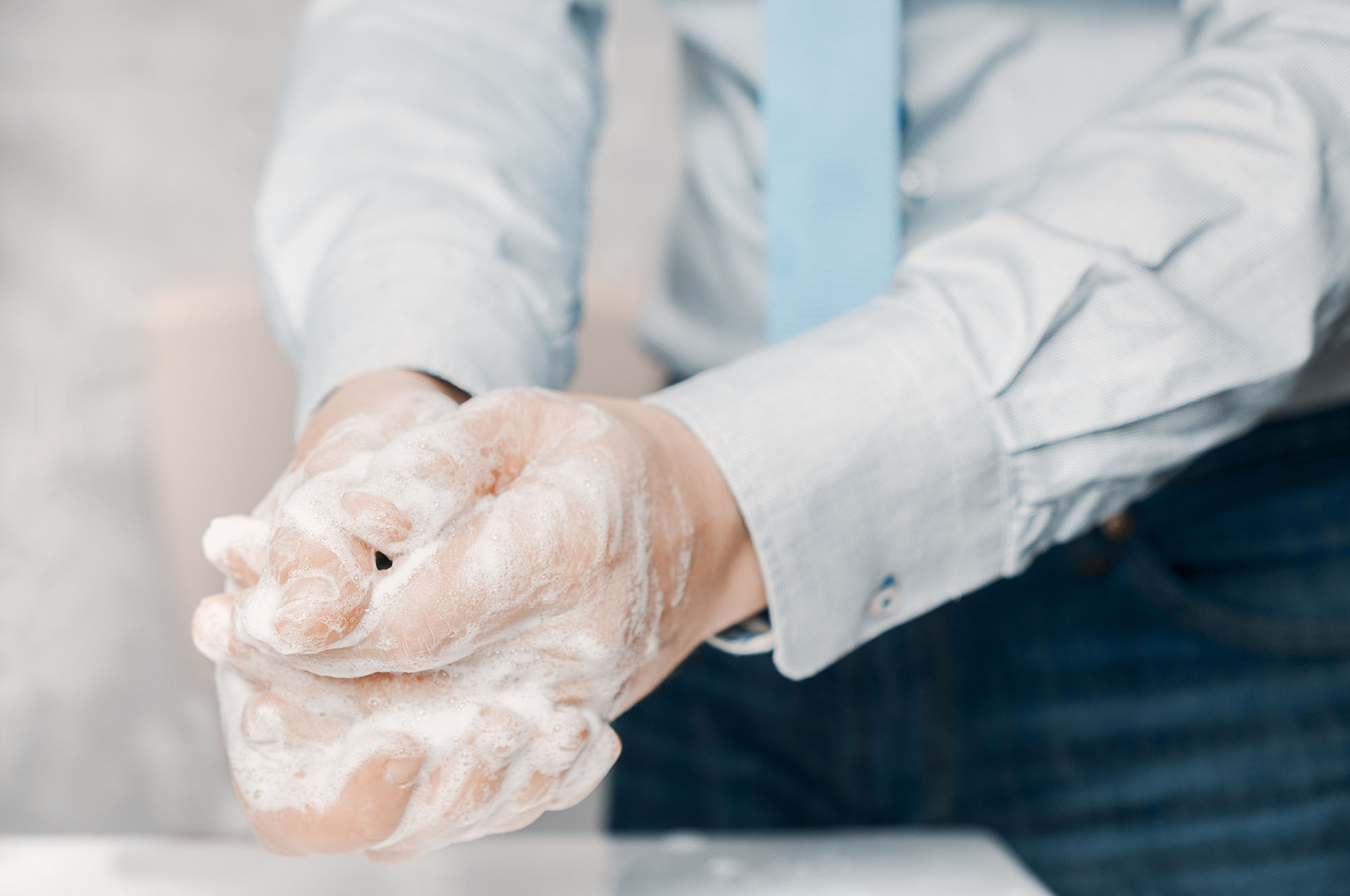 a man in a suit washes his hands