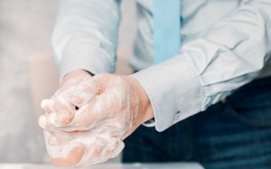 a man in a suit washes his hands