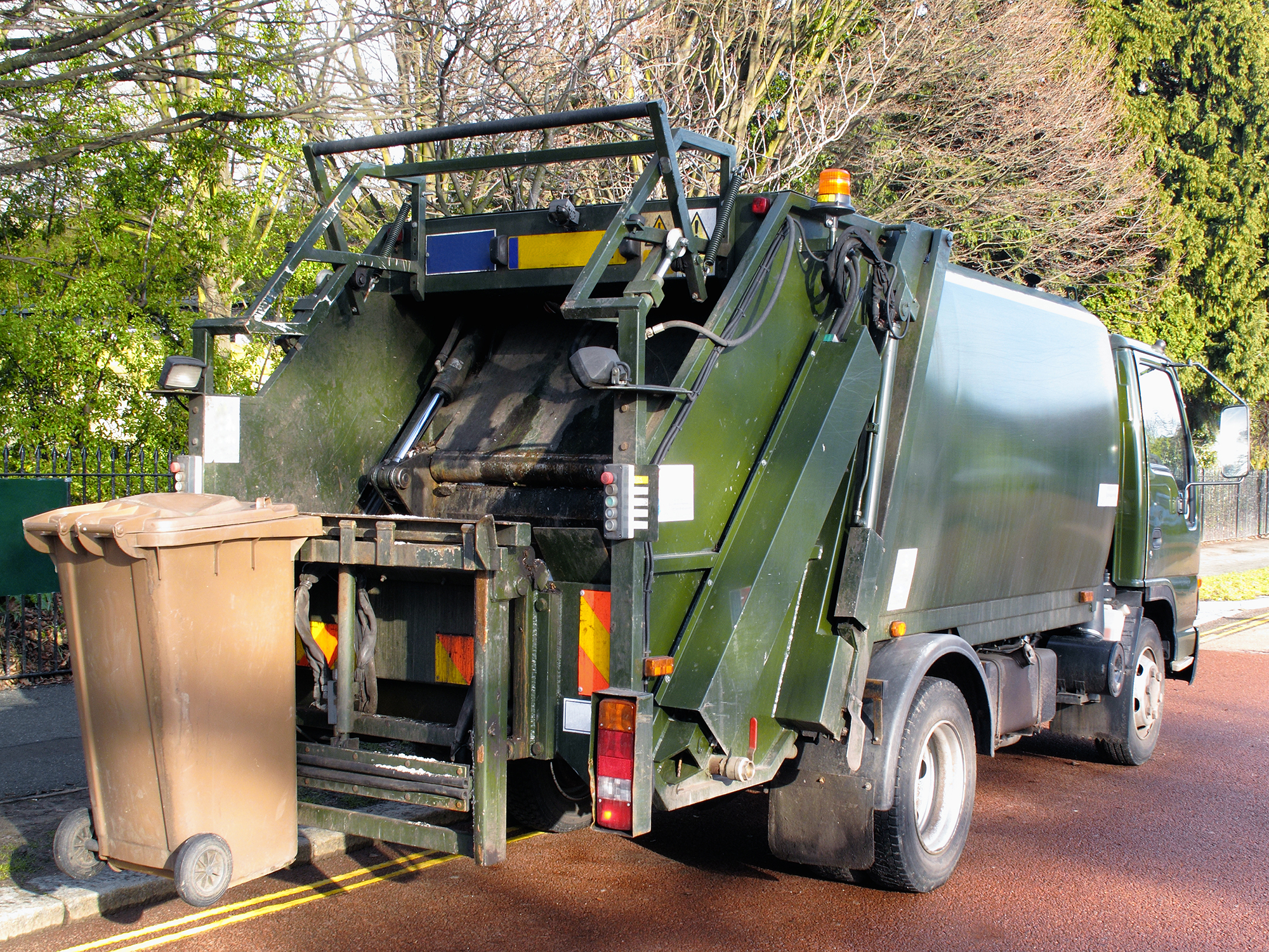 a refuse truck collects a brown bin